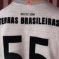 Detalhe da parte de trás de camiseta cinza com a frase "Feito em Terras Brasileiras" e número 55 em preto