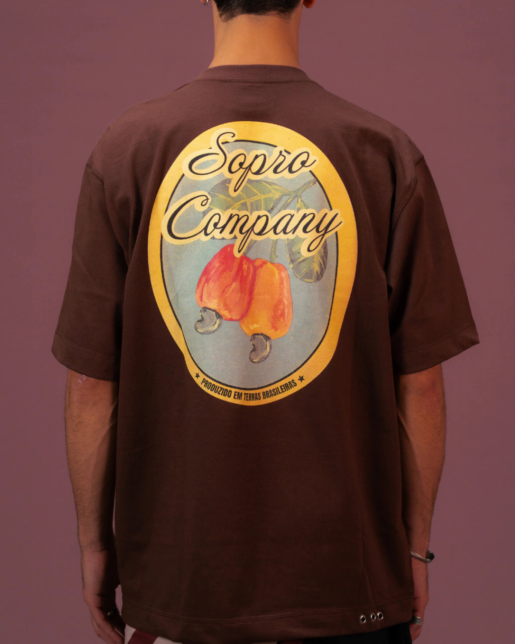 Camiseta oversized marrom com estampa colorida de caju e texto "Sopro Company" nas costas