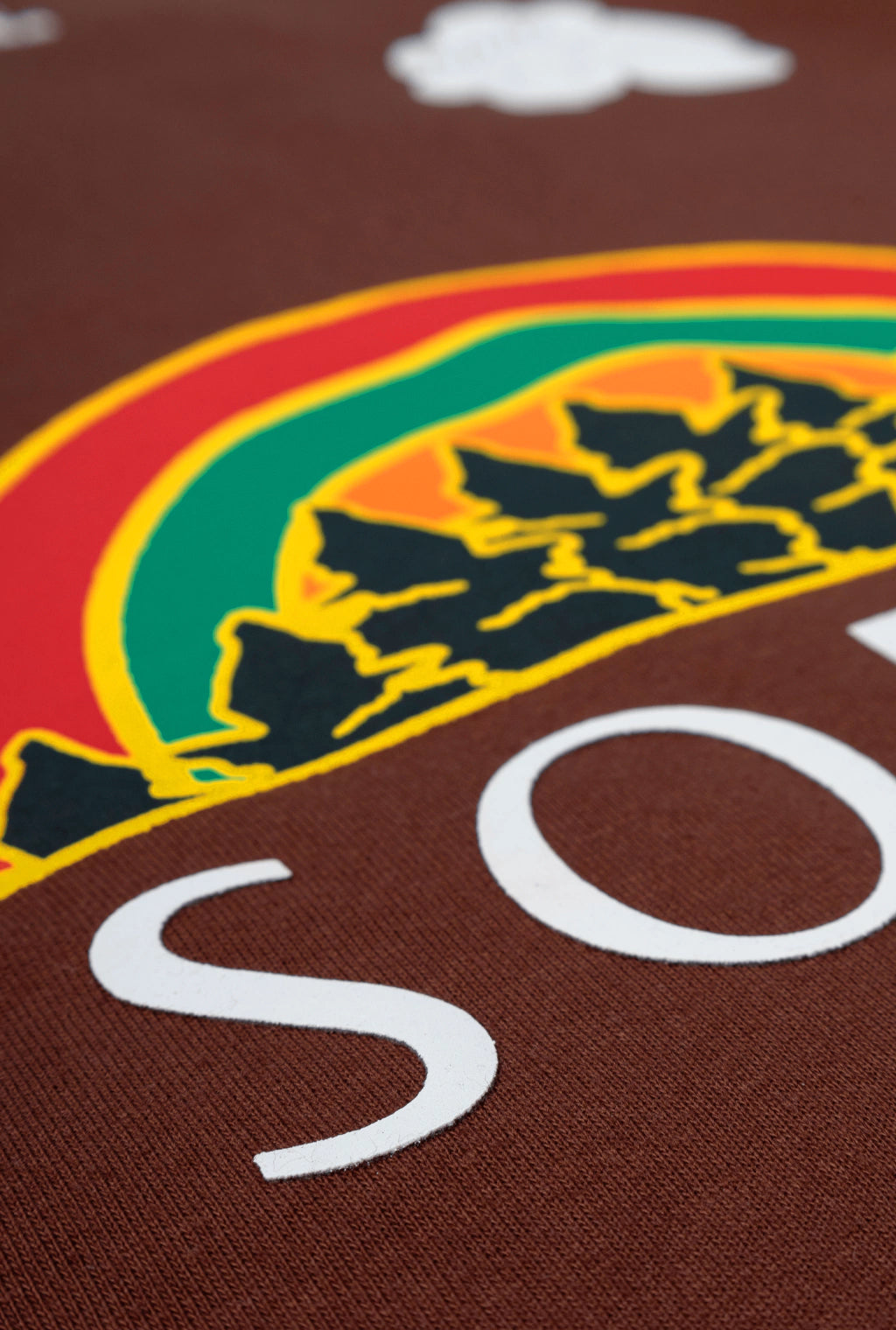 Camiseta Rolimã Racing Marrom com estampa arco iris e detalhes em bege da marca "SOPRO"